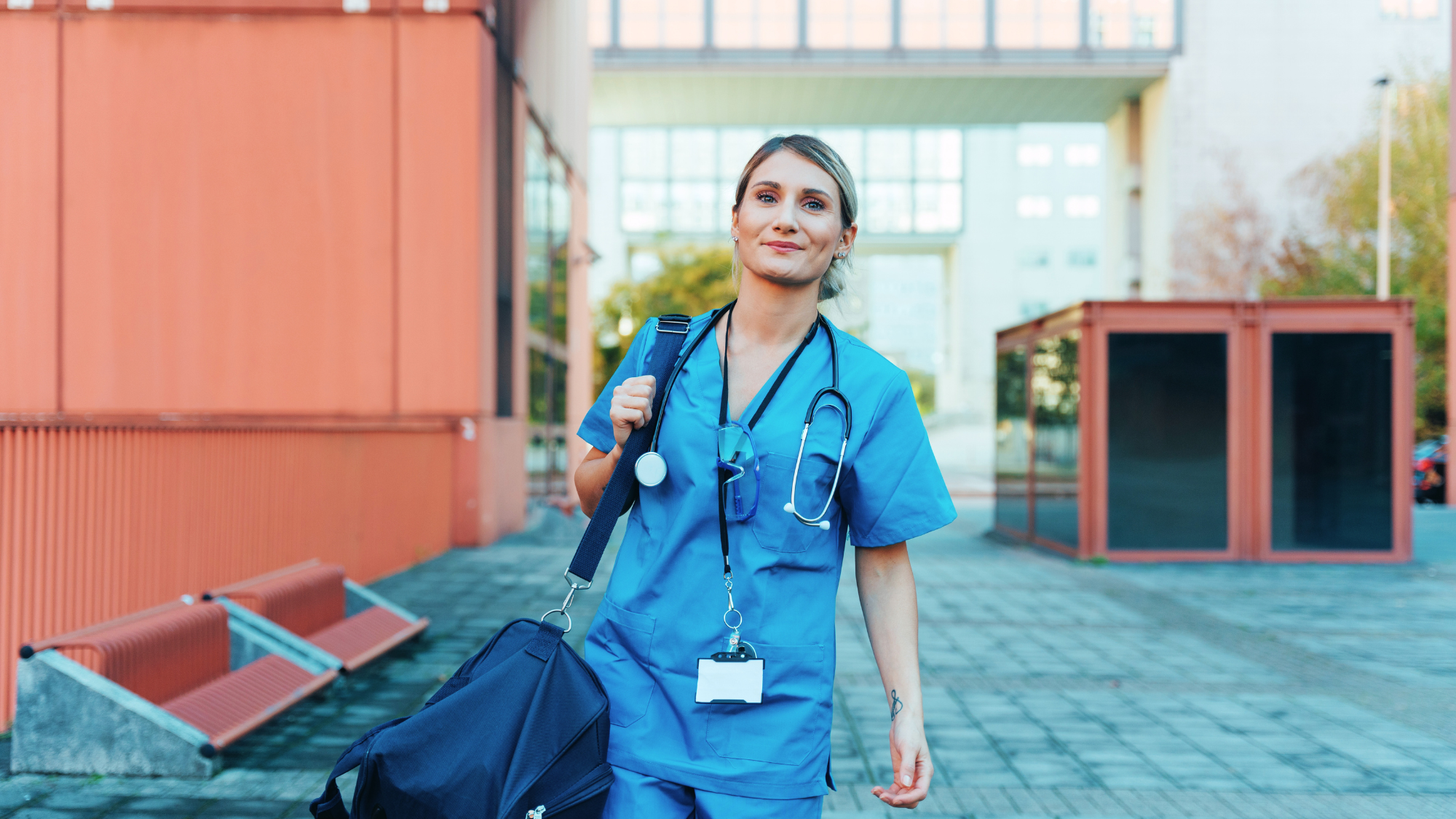 Female nurse leaving the hospital with her bag.