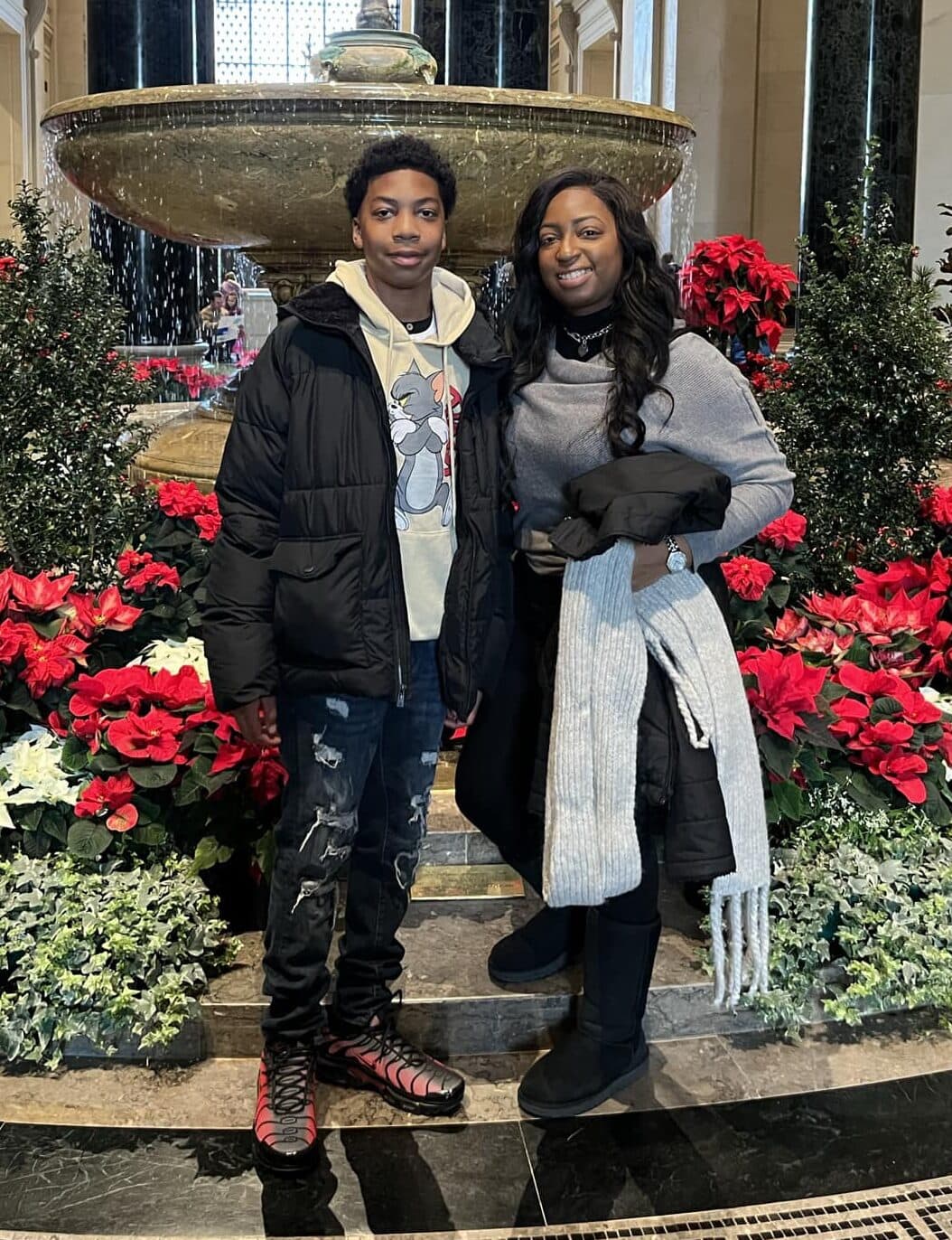 Mother and son standing in front of fountain