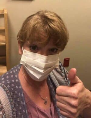 image of Leigh Anne with face mask on and holding a thumb up