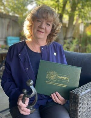 image of leigh anne thomas holding daisy award