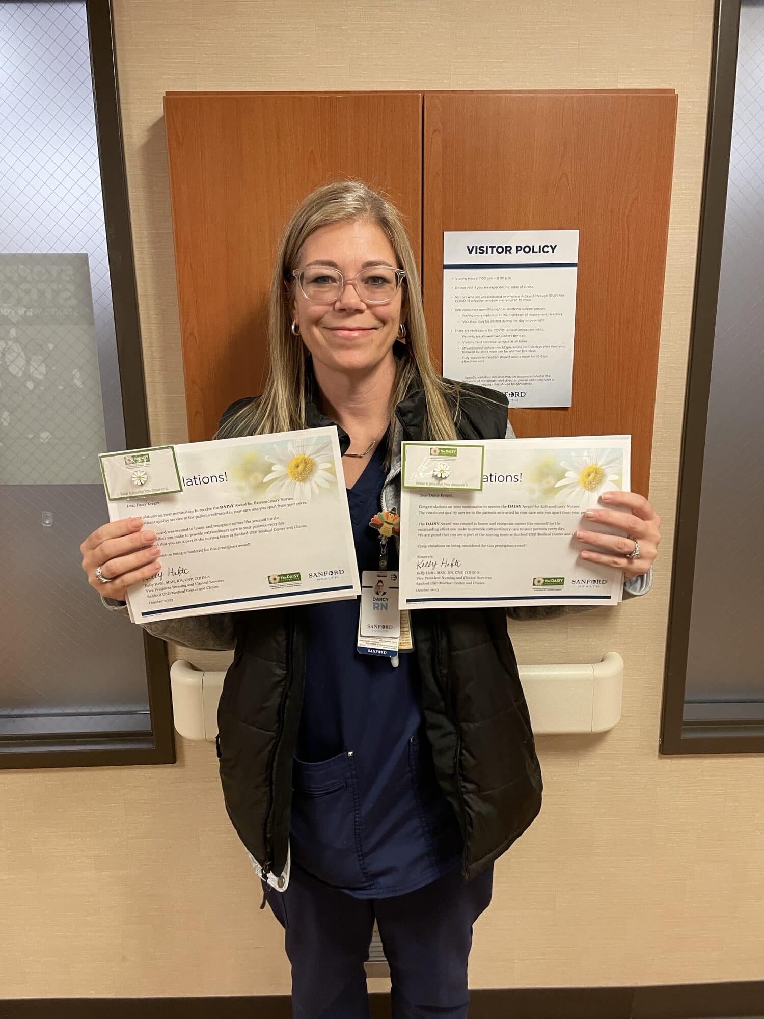 Darcy Kreger holding Daisy Award win 2 and 3