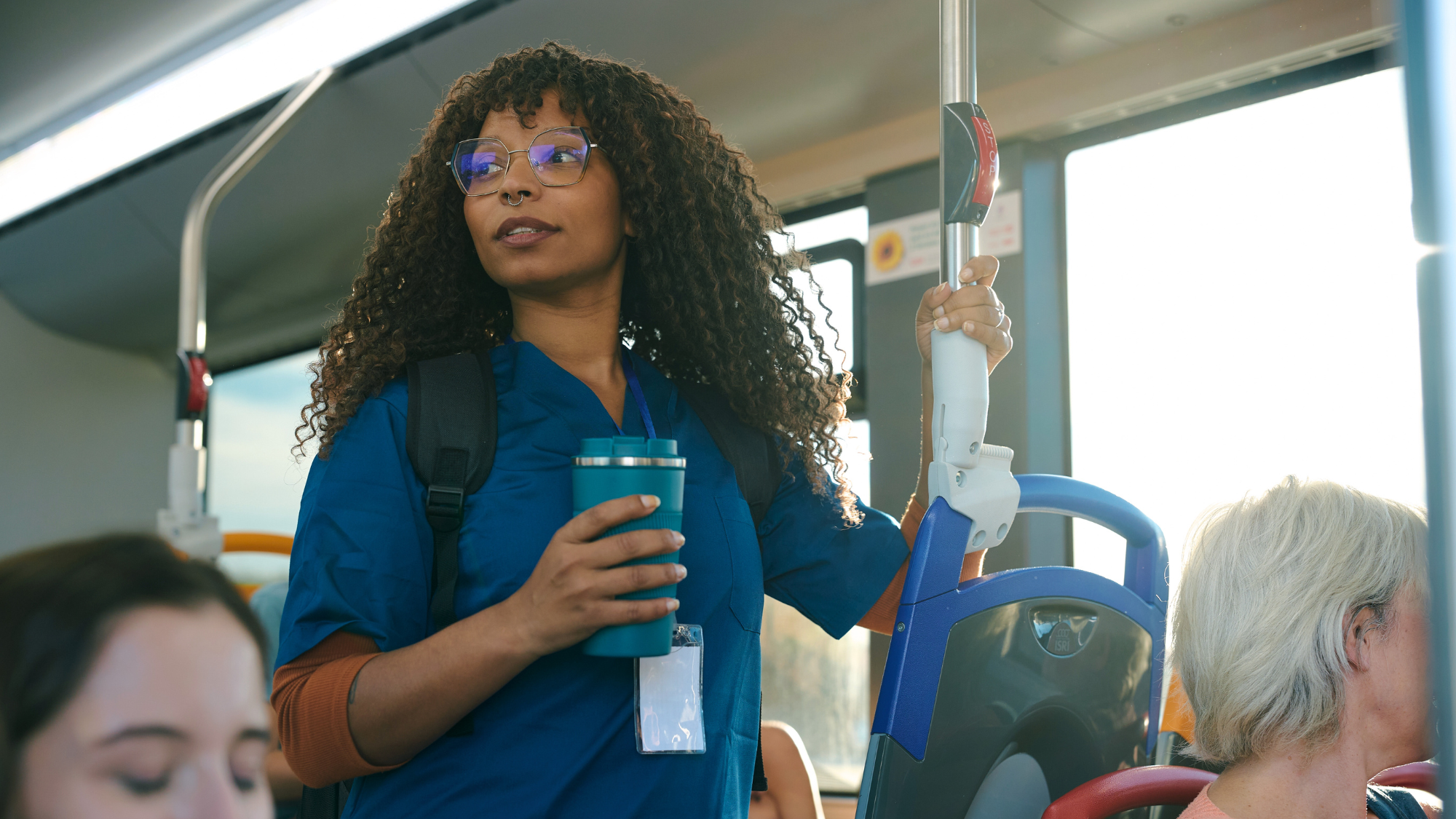 Young nurse holding a cup on the bus