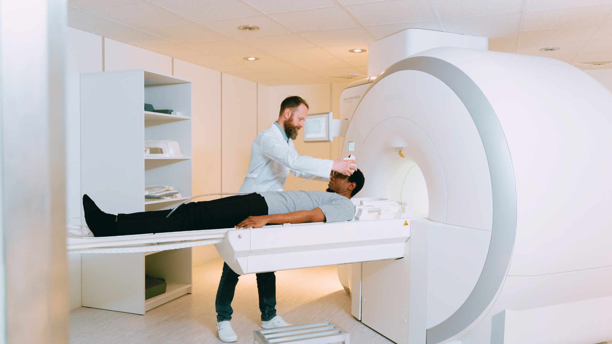 Man getting an MRI and being assisted by male MRI tech