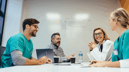 healthcare-professionals-around-conference-room-table-with-whiteboard-in-background