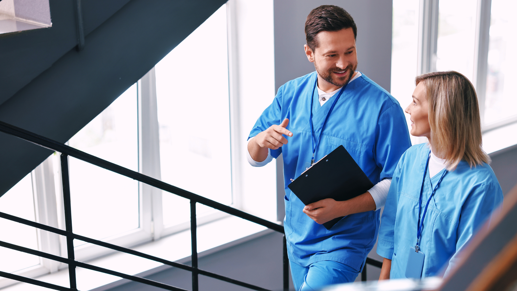 Male and female nurse walking up stairs together.