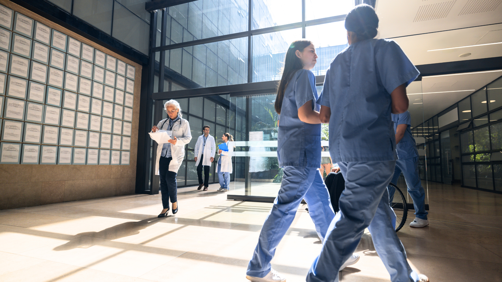 healthcare employees walking around lobby near entrance of facility